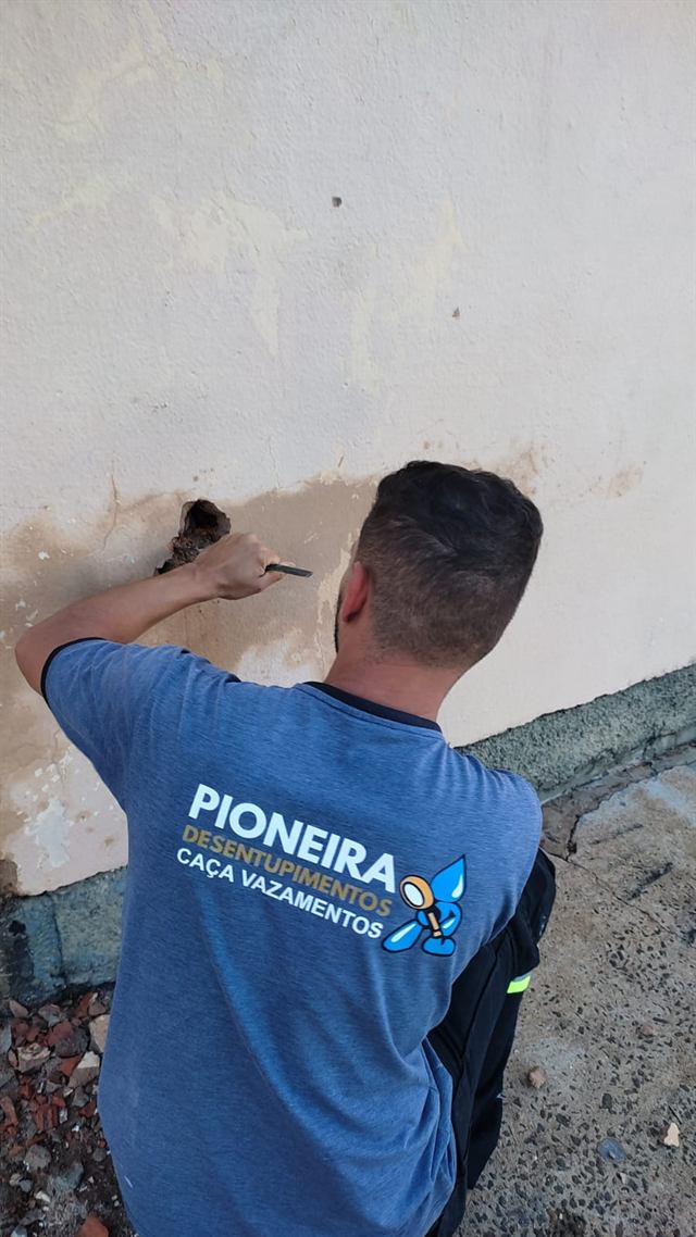 Técnico da Pioneira abrindo a parede no ponto exato de um vazamento